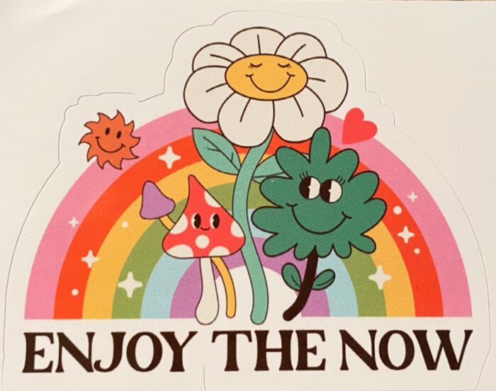 A sticker of flowers and trees with the words " enjoy the now ".