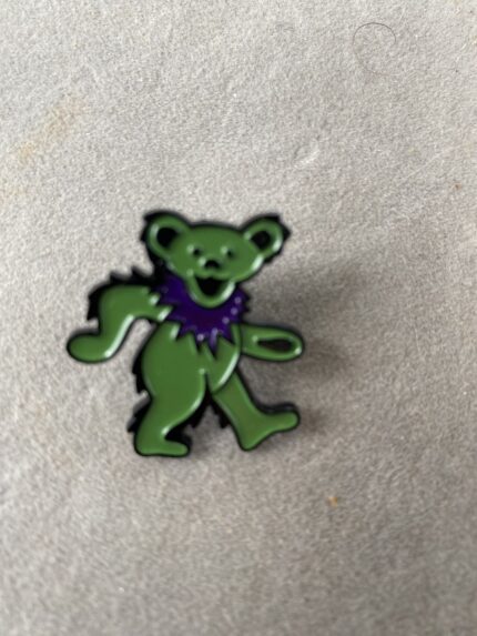 A green bear with purple collar on the floor