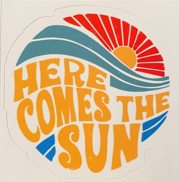 A sticker that says here comes the sun