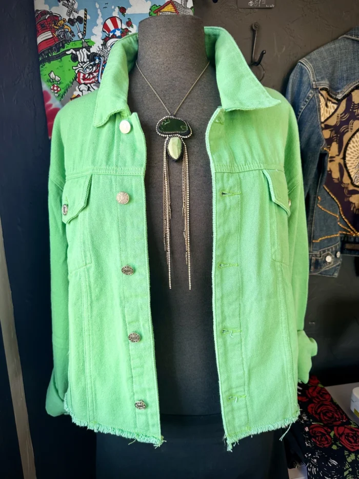 A green jacket is hanging on the mannequin.