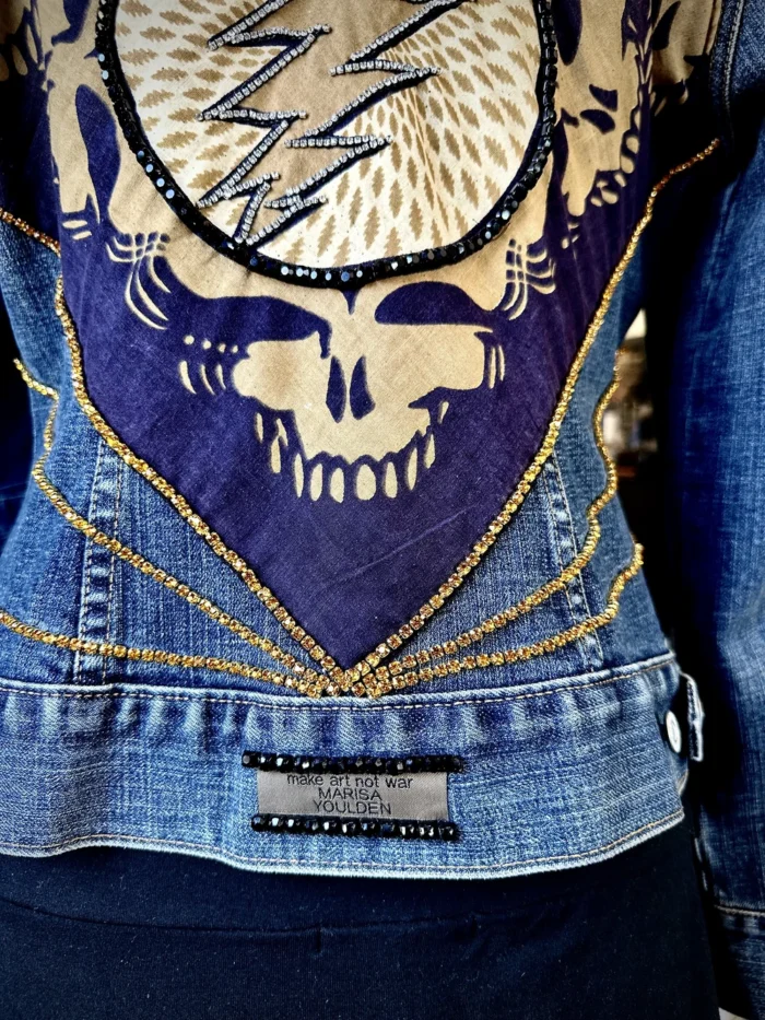 A close up of the back of a jacket with chains and skulls