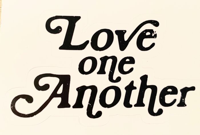 A black and white image of the words love one another.