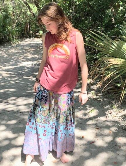 Woman wearing a daydreamer shirt and floral pants.