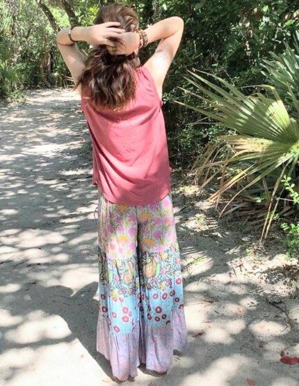 Woman wearing floral print pants outdoors.