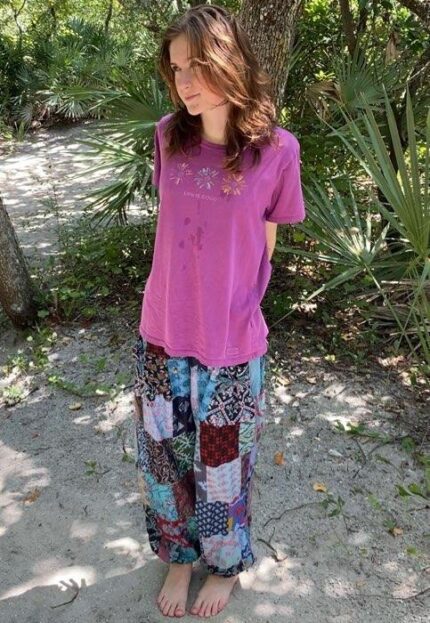 Young woman wearing pink shirt and patchwork pants.