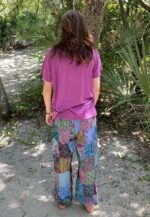 Woman in pink shirt and patchwork pants.