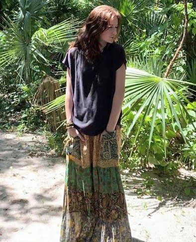 Woman in black shirt and patterned skirt.