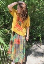 Woman wearing yellow shirt and patchwork skirt.