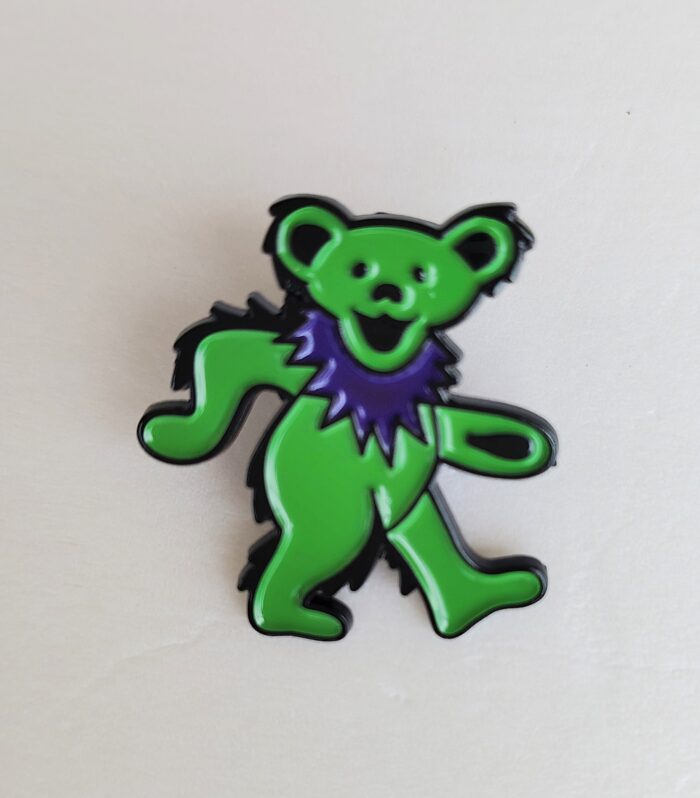 Green bear with purple collar pin.