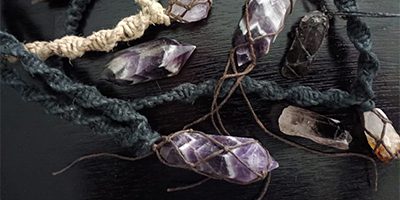 Purple and black crystal pendants on string.