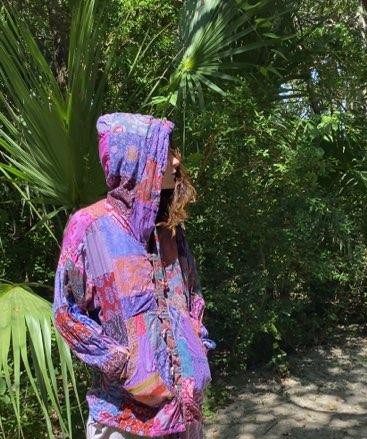 Person wearing a colorful patchwork hoodie.