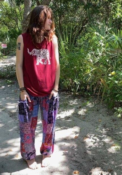 Woman wearing red tank top and patterned pants.