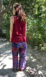 Woman in red tank top and patterned pants.