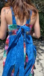 Woman wearing a galaxy print dress with a blue bow.