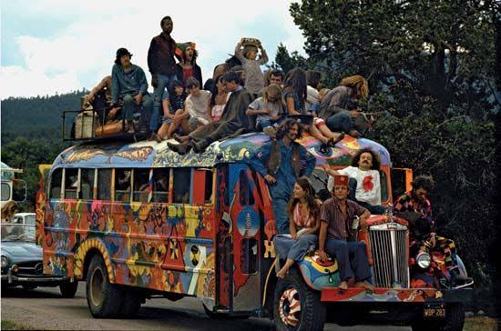 Hippie bus with colorful paint and people.