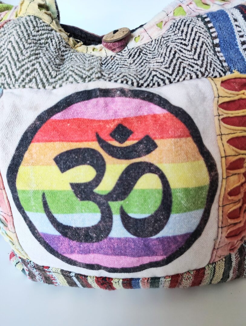 Rainbow Om symbol on a patchwork bag.