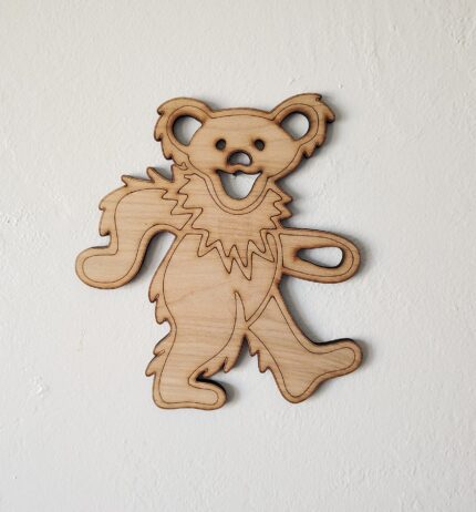 Wooden cutout of a smiling bear.