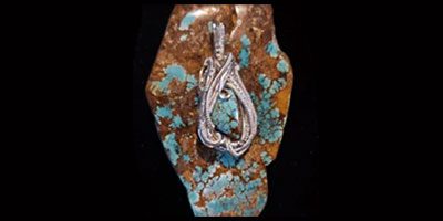 Silver pendant with turquoise stone inlay.