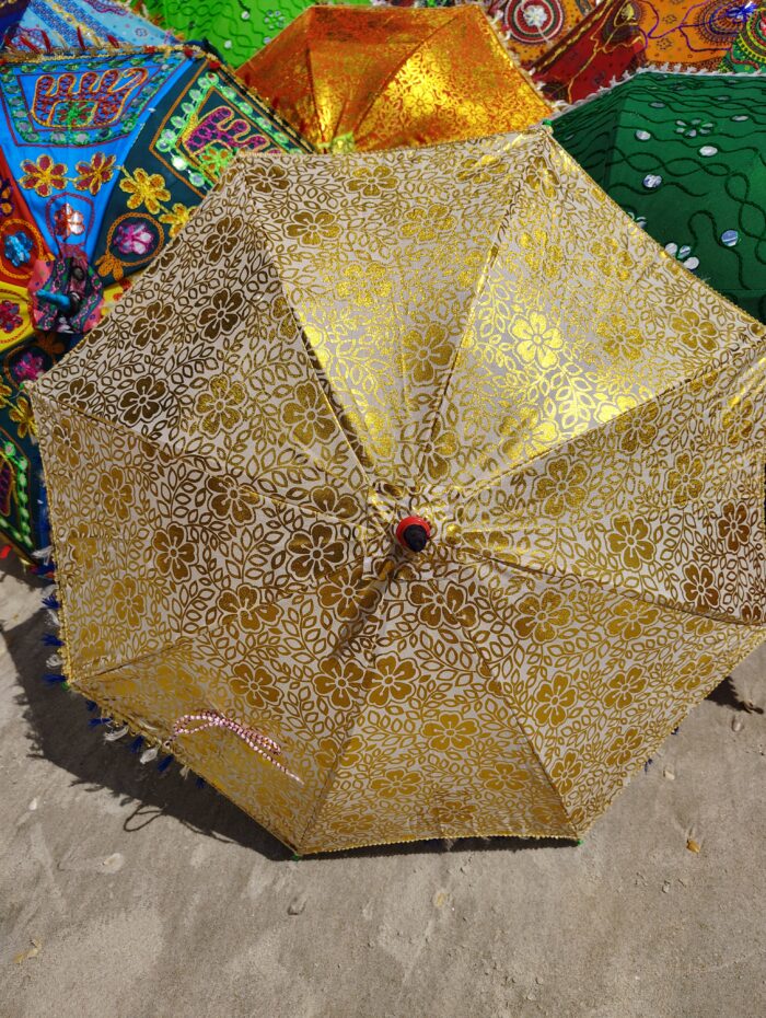 Gold floral umbrella on a beach.