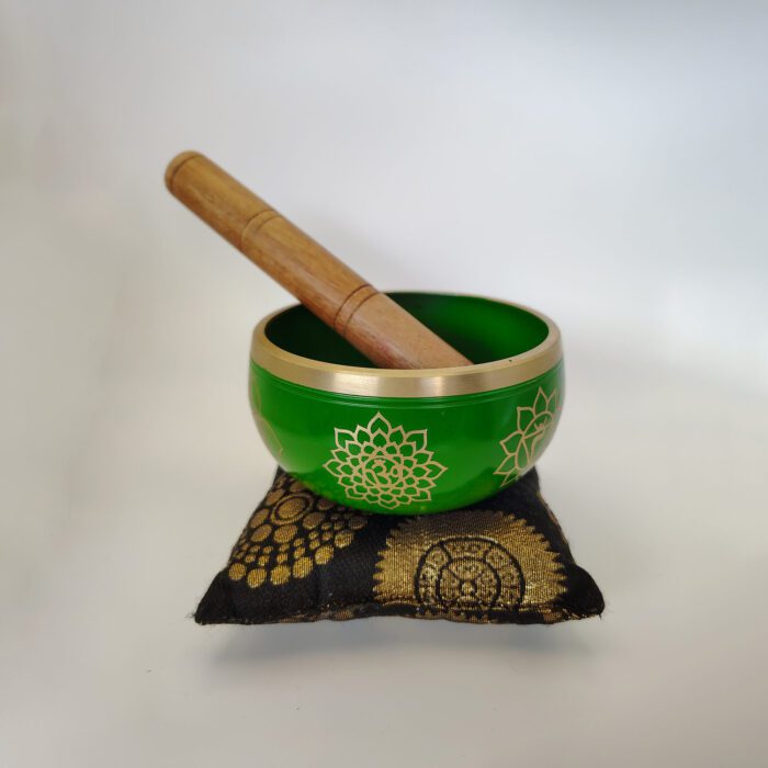 Green singing bowl with mallet and cushion.