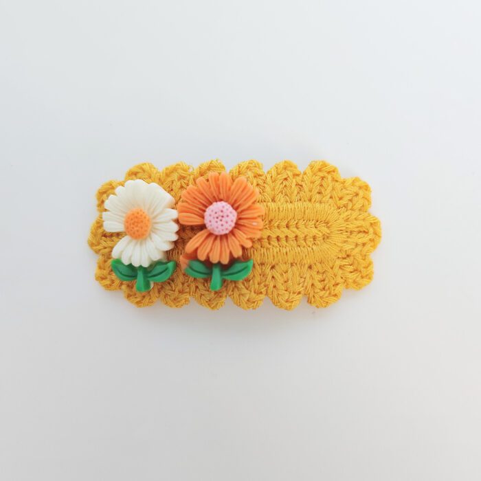 Yellow crocheted hair clip with flowers.