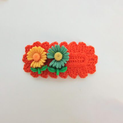 Orange crochet hair clip with flowers.