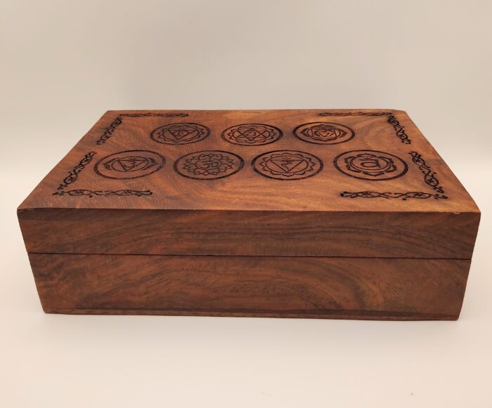 Wooden box with carved chakra symbols.