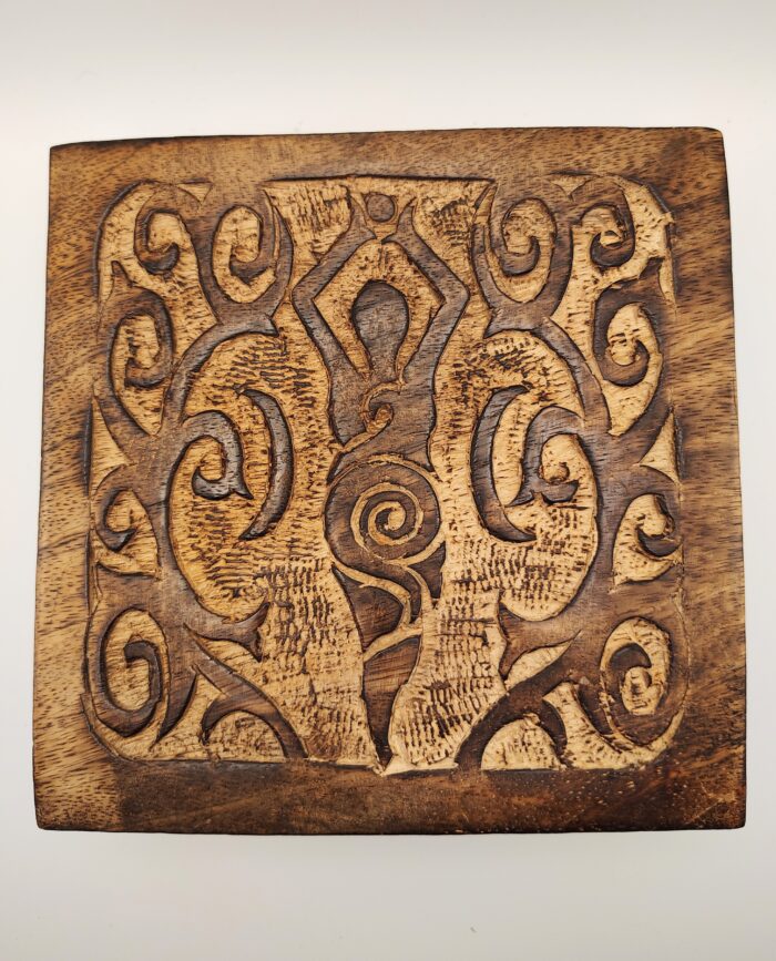 Carved wooden plaque with intricate swirls.