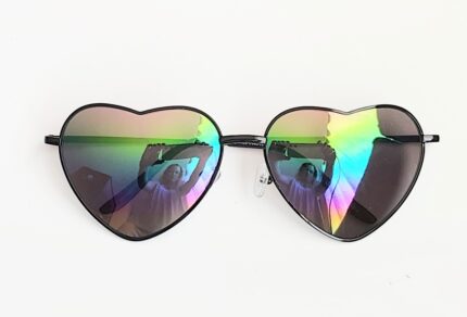 Heart-shaped iridescent sunglasses with reflection.