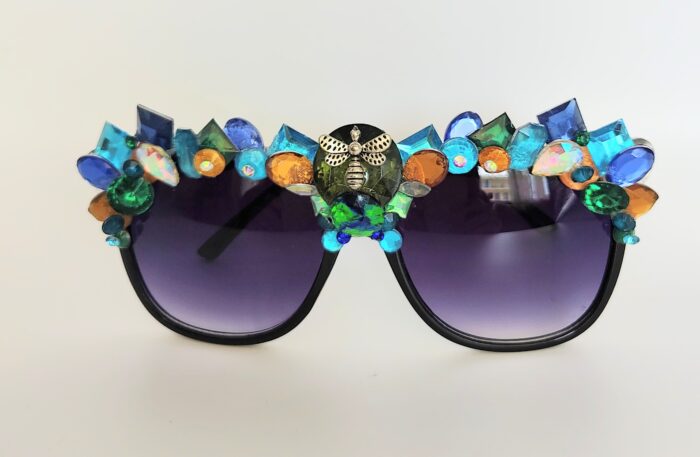 Black sunglasses with jeweled bee design.