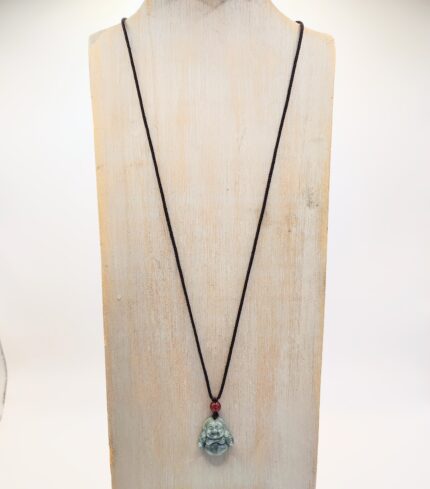 Jade Buddha necklace on a wood stand.