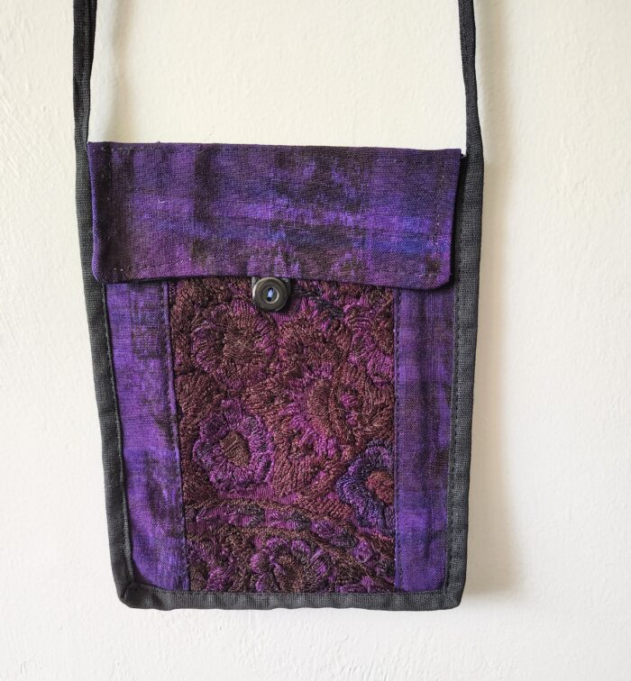 Purple fabric purse with floral detail.