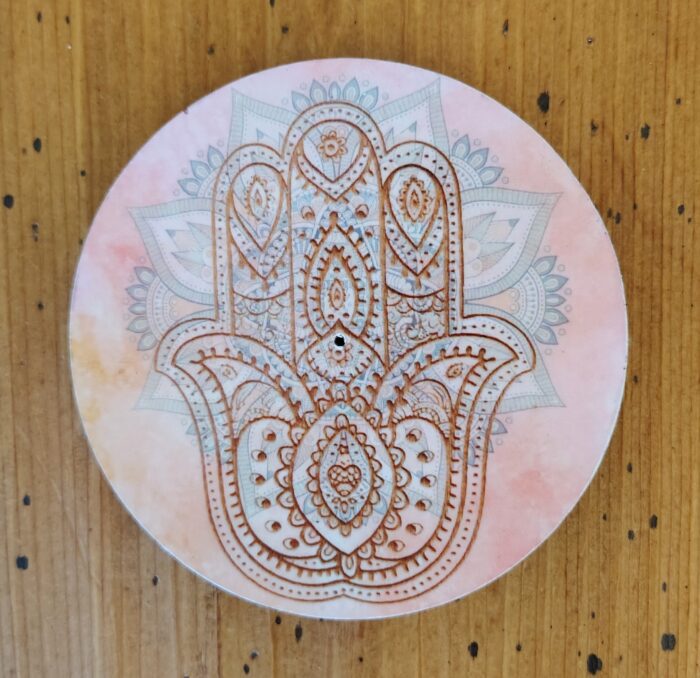 Hamsa hand incense burner with mandala design.