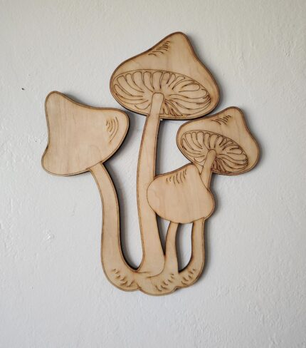 Wooden cutout of three mushrooms.