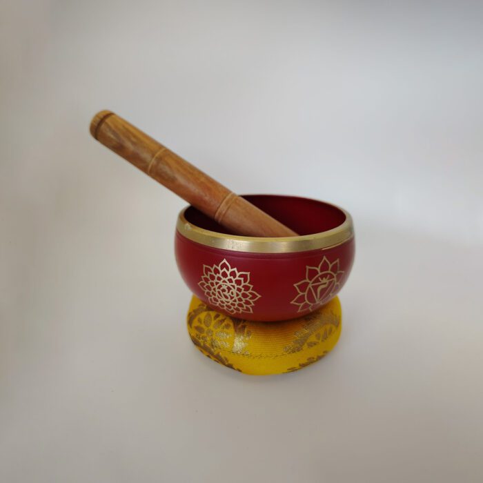 Red singing bowl with mallet and cushion.