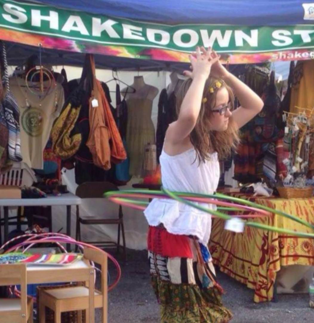 Girl with hula hoops at market stall.