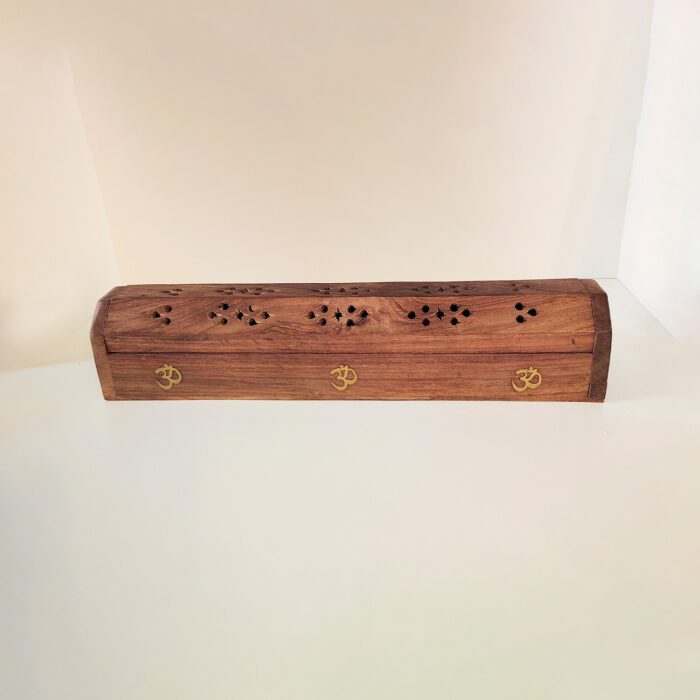 Wooden incense burner with Om symbols.